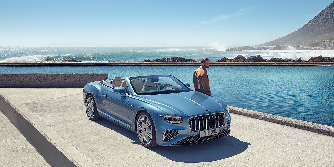 JCT600 Limited New Bentley Continental GTC Azure convertible front view in Light Windsor blue paint with 22 inch ten spoke wheels parked by the sea in the sunshine